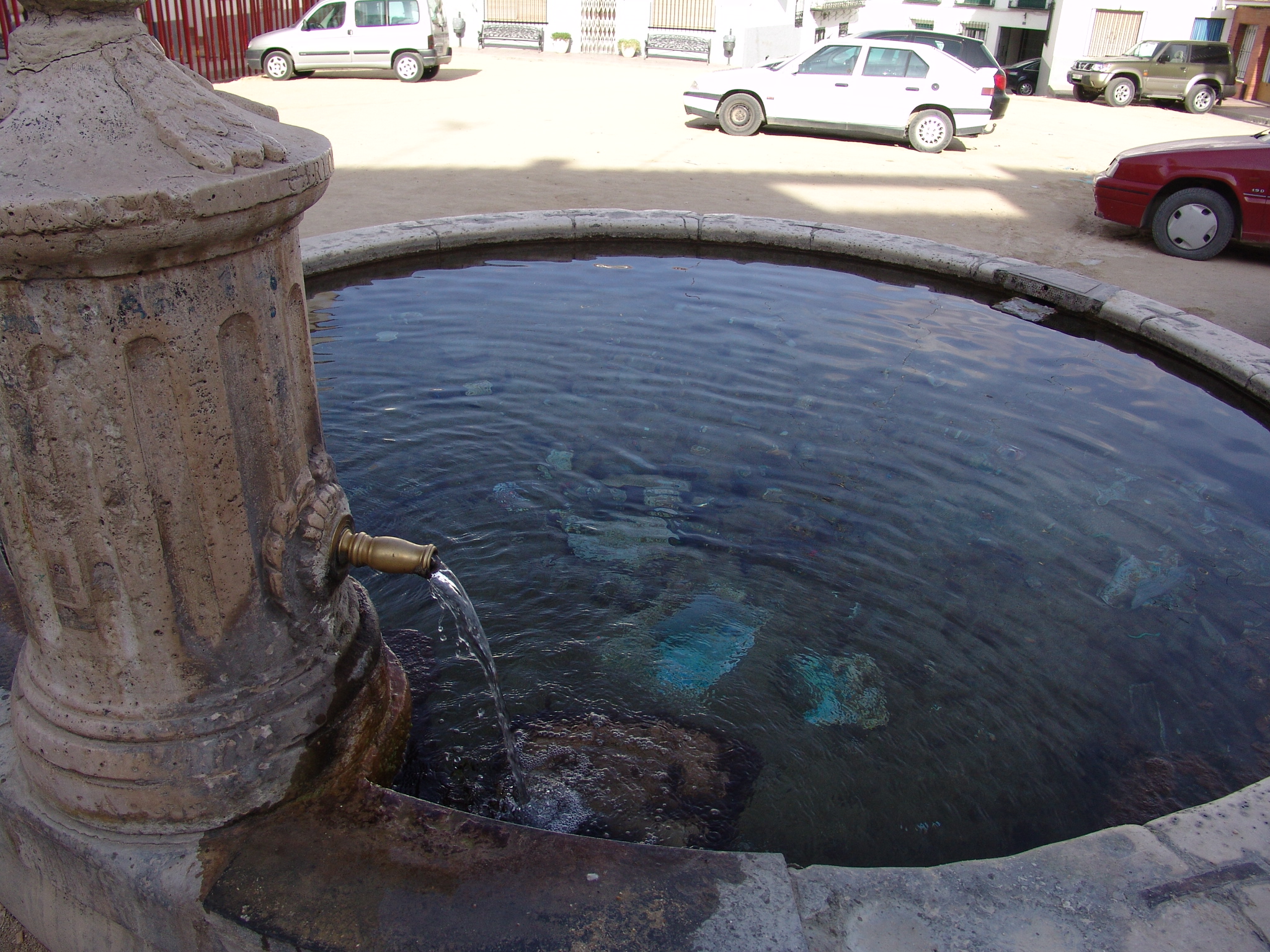 se encuentra formada por un pilón circular de piedra caliza de Colmenar, con dos caños de bronce que vierten el agua a ambos costados, rematándose por una pieza en forma de cono, decorada con guirnaldas de hojas y coronada por una bellota