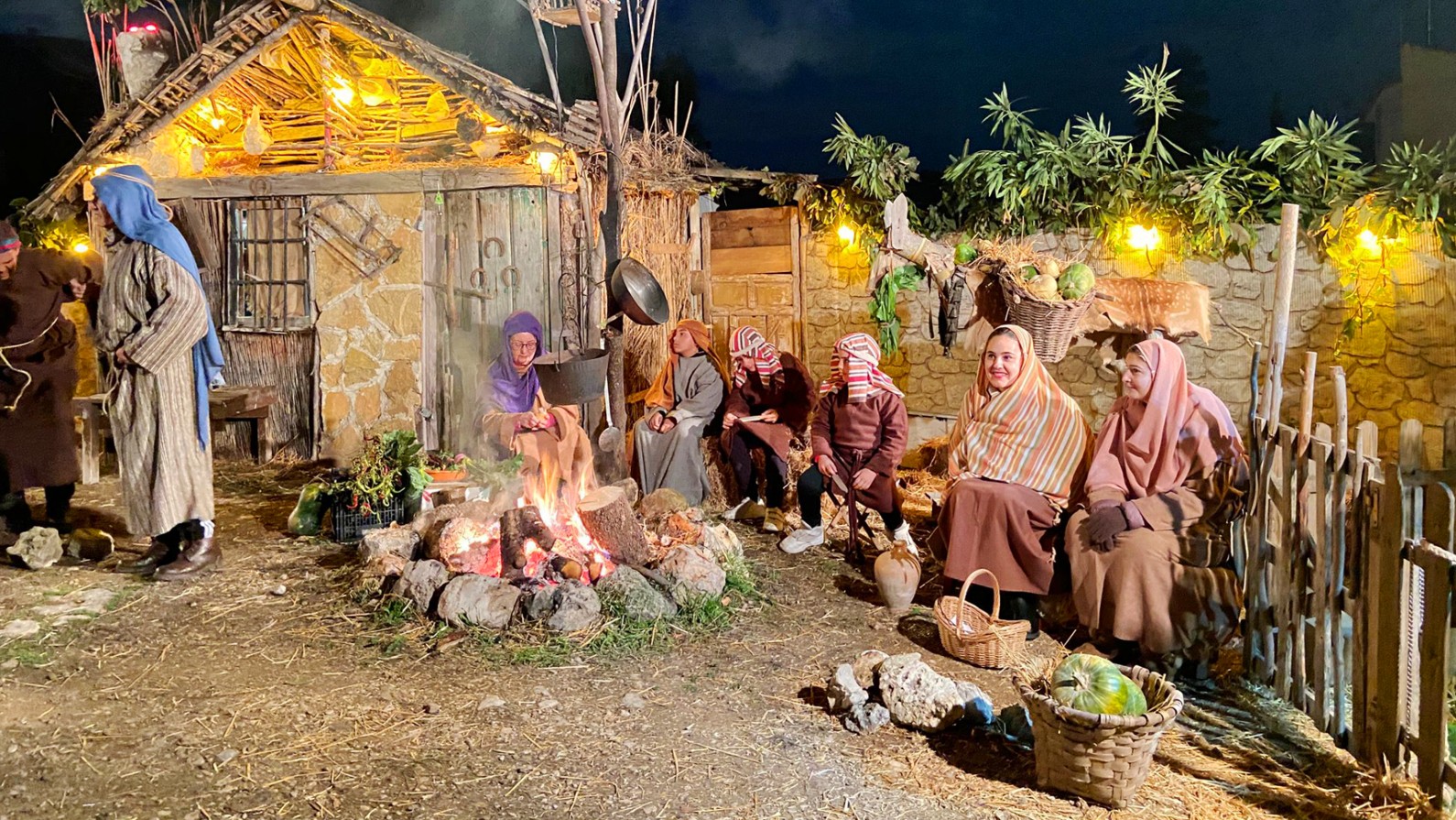 Scene from the Living Nativity, where shepherds can be seen gathered around the bonfire.