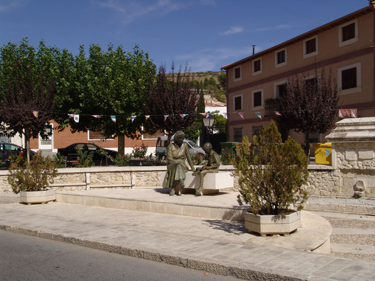 View of the ensemble made up of a curved basin in dressed stone with two square-section pillars topped by truncated pyramids, each with two spouts. In the centre stands the Fan Fountain, also known as the Mariblanca Fountain.