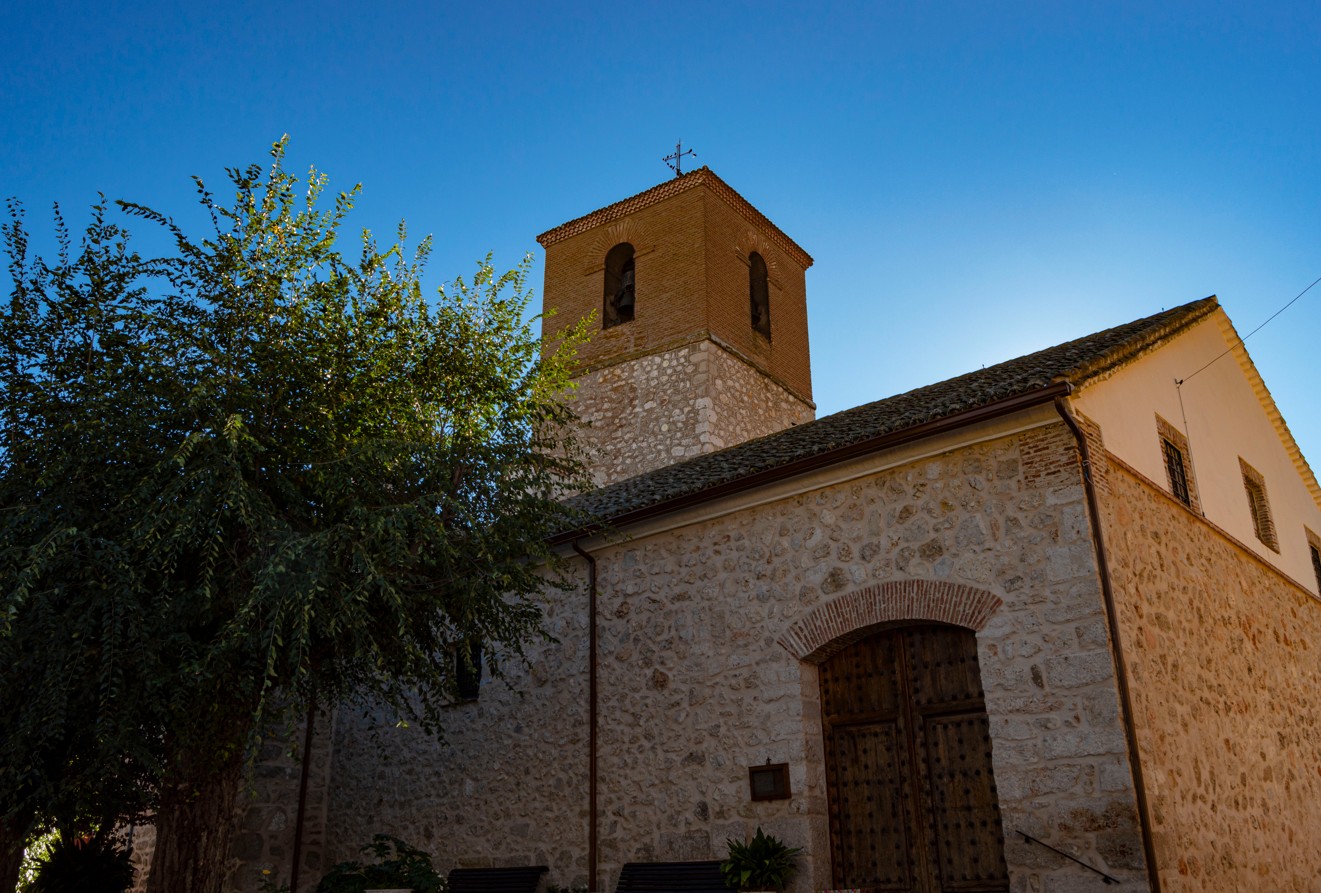 Iglesia de Santa María Magdalena. Entorno de la Iglesia de Anchuelo, destacando su torre en la que se aprecian en el cuerpo más moderno las campanas en cada cara.