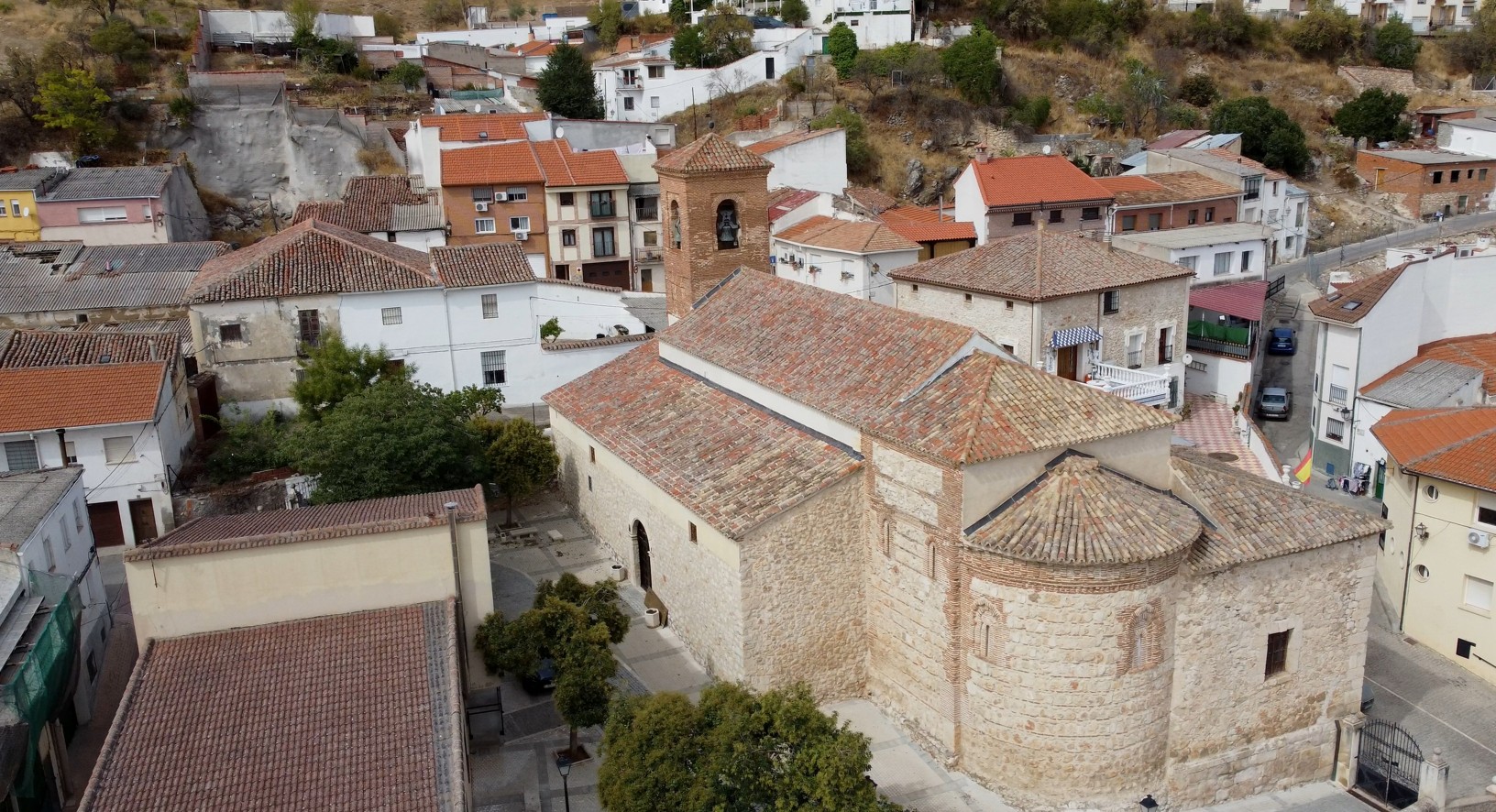vista de la iglesia de Valdilecha construida en piedra y ladrillo, siguiendo modelos arquitectónicos del mudéjar toledano.