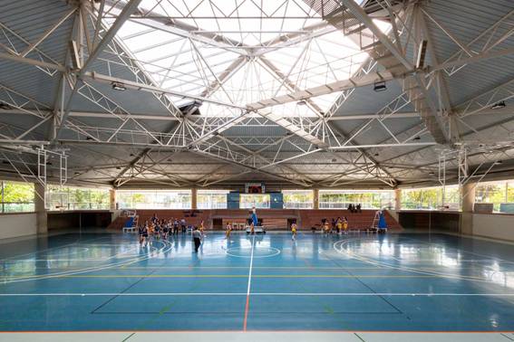 Imagen del interior de un pabellón deportivo con una cancha de baloncesto.