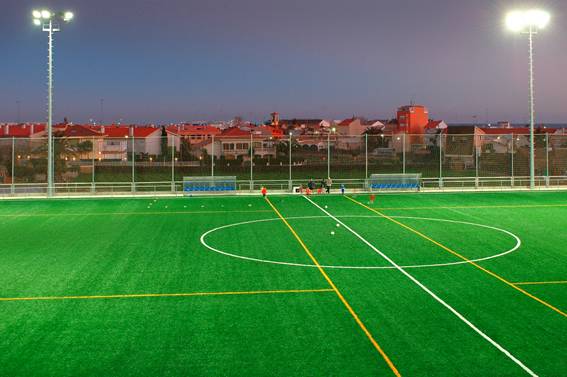 Imagen del campo de fútbol con los focos iluminados.