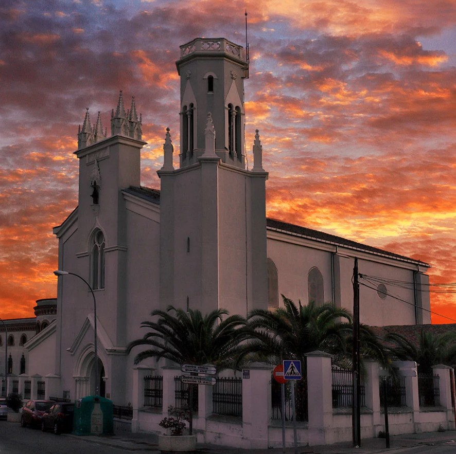 moderna iglesia construida en el año 1908, está construida en estilo neogótico. Anexo se encuentra un edificio histórico, réplica del original, que en su fachada combina el estilo neomudéjar y el neoclásico con el modernismo.  