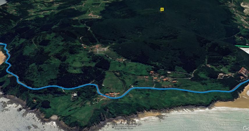 Imagen de la ruta sobre un terreno de verdes intensos en paralelo al mar. A izquierda y derecha hay arenales