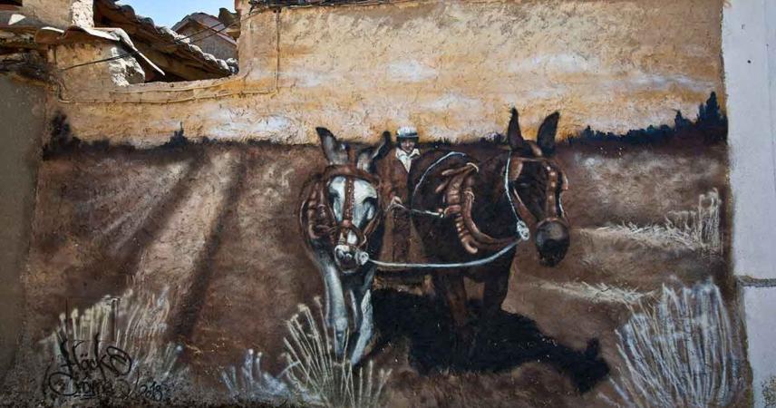 Peinture murale représentant un homme labourant avec deux mules
