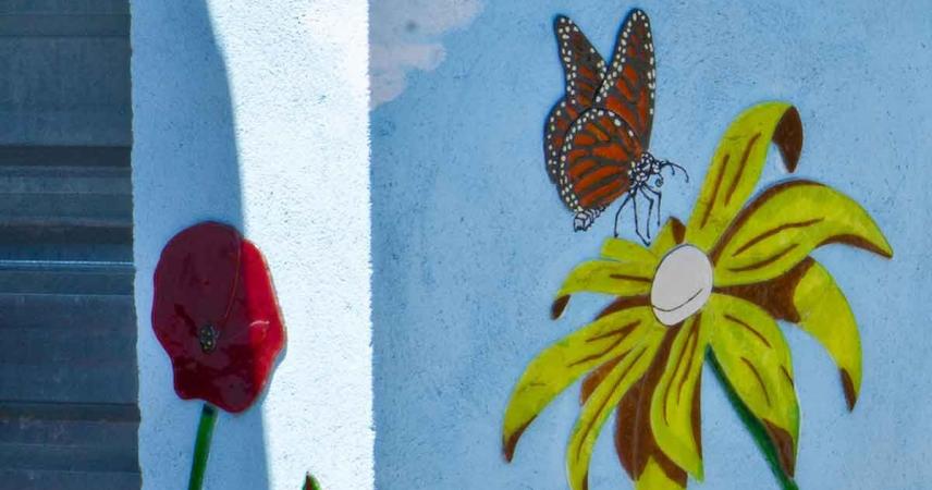 Peinture murale de fleurs colorées et d&#39;un papillon, sur fond bleu ciel