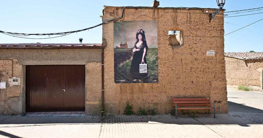 Peinture murale d&#39;une femme dans un pré avec un sac d&#39;El Corte Inglés sur lequel est écrit « La Torre del Valle »