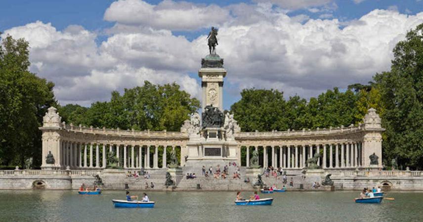 Photo de l'étang du Retiro dans lequel on peut voir des gens dans des bateaux. Sur l'image, vous pouvez voir que l'étang est entouré par le monument à Alphonse XII, qui se dresse sur la rive est, qu'il envahit au moyen d'un grand escalier semi-circulaire, qui entre dans les eaux, comme une jetée. 