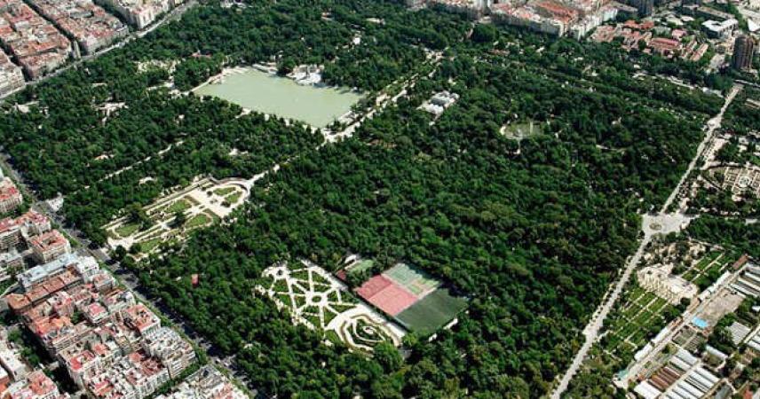 Photographie aérienne du parc, qui montre un grand espace vert grâce aux arbres et aux jardins, entouré de bâtiments. Dans la zone verte, on peut voir l'étang.