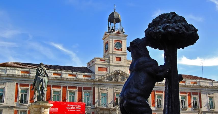 Sur cette photo, on peut voir l'horloge qui sonne, la statue équestre de Charles III de dos et la statue de l'Ours et de l'Arbousier.