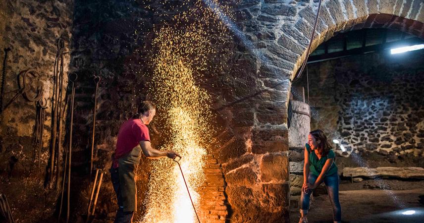 A couple smelting iron in the forge