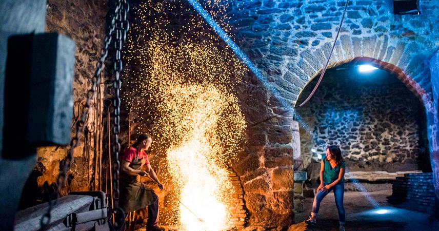 A couple smelting iron in the forge