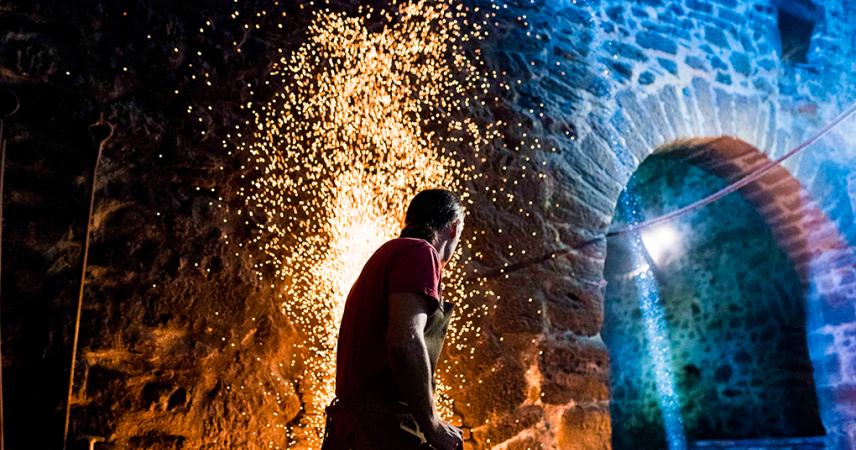 A couple smelting iron in the forge