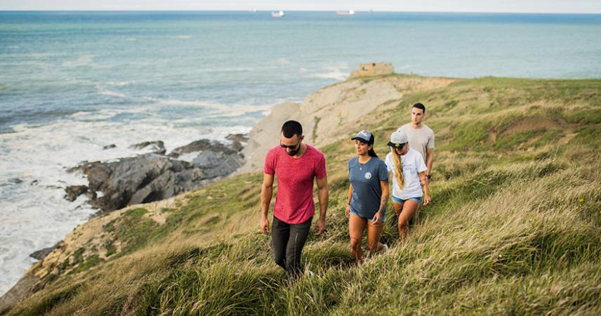 Grupo de amigos paseando en una zona de montaña cerca de la playa