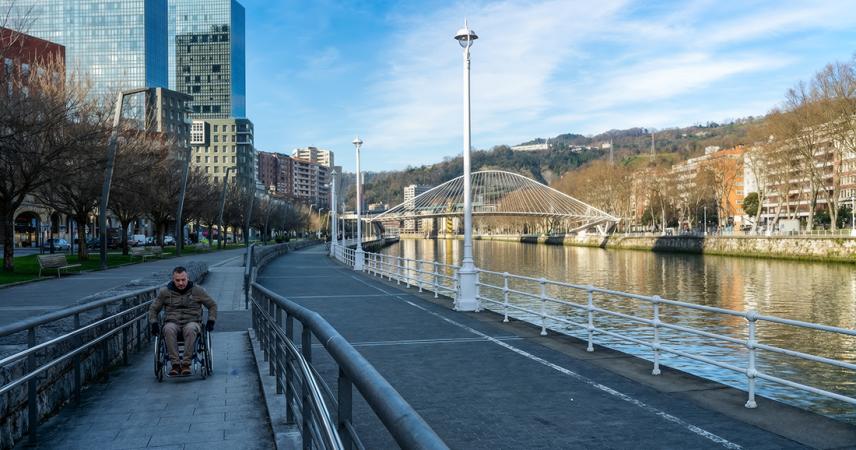 Una persona en silla de ruedas por el camino de la ría de Bilbao